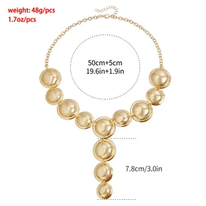 Gold tone chunky Y-shaped necklace featuring polished circular disks with specs