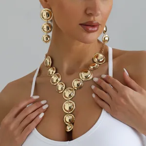 Detailed close-up of a chunky gold geometric Y-shaped necklace and earrings set