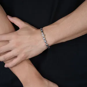 Detailansicht eines Herren-Armbandes mit Kaffeebohnenperlen und einem Silberkreuz.