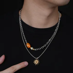 Vue détaillée d'un collier double rang avec pendentif soleil doré et perle orange élégante