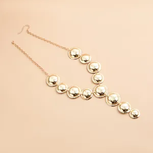 Detailed view of a gold Y-shaped necklace featuring polished geometric metal discs