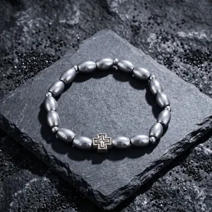 Detailansicht eines Herren-Armbands mit Kaffeebohnen-Perlen und einem Kreuz-Anhänger