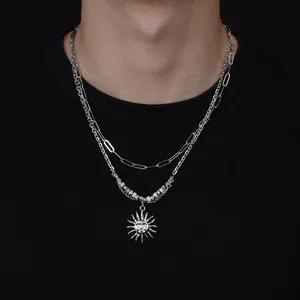 Gros plan sur collier double couche argenté avec pendentif soleil et perles