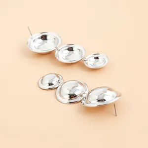 Macro detail of vintage metallic silver triple disc earrings for elegant party wear