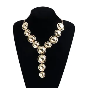 Detailed view of a gold geometric Y-shaped necklace on a black jewelry display bust.