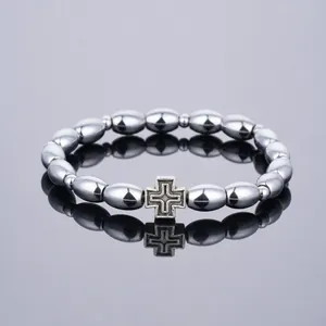 Detailansicht Metall-Kaffeebohnen-Armband mit einem silbernen Vintage-Kreuzanhänger
