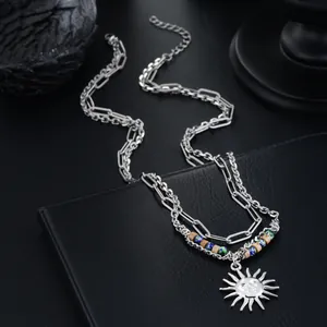 Gros plan d'un collier argenté double couche avec un pendentif en forme de soleil détaillé