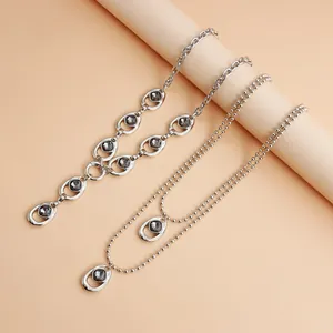 Dettaglio della collana a Y argento e catena a sfere con pietre nere.