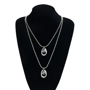 Collana a Y a due strati in argento con perle e pendenti ovali in pietra nera lucida