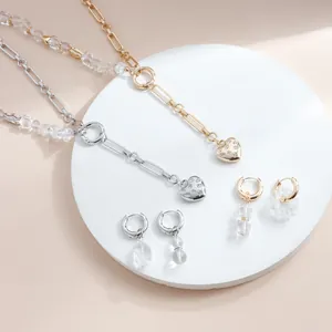 Detailed view of luxury crystal heart necklace and earring set in gold and silver finishes.
