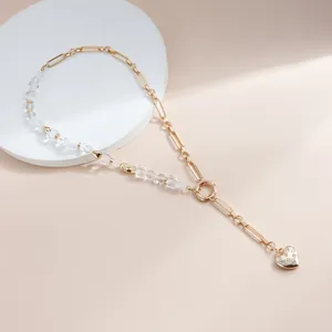 Close-up of gold Y-shaped necklace with crystal beads and pavé heart pendant.