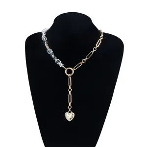 Close-up detail of a vintage style gold Y-necklace featuring crystals and heart pendant