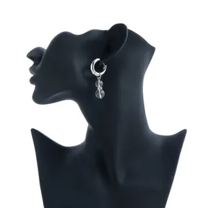Detail view of silver hoop earring with clear crystal beads on black mannequin bust