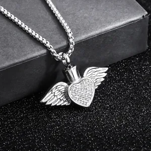 Close-up of angel wings heart pendant with pavé crystals on a black box