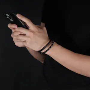 Close-up of men's double-layer braided leather and beaded bracelet worn on the wrist