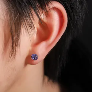 Primer plano de un pendiente de titanio F136 con circón morado de corte rosa.