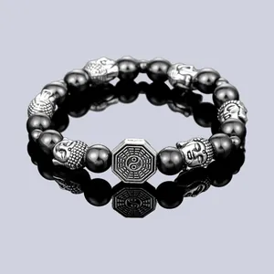 Primer plano detallado de una pulsera de cuentas negras con cabezas de Buda y dije de Taiji.