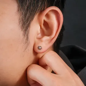 Detailed close-up of a snowflake-shaped titanium stud earring with a zircon stone