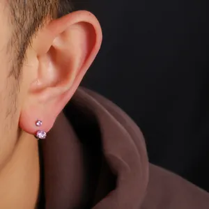 Makro-Detailaufnahme eines F136 Titan-Hufeisenohrrings mit zwei rosa Steinen am Ohr.