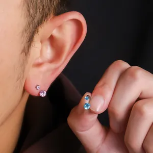 Detail des F136 Titan-Hufeisen-Piercings mit funkelnden blauen und rosa Steinen.