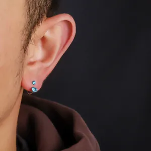 Nahaufnahme eines F136-Titan-Hufeisenrings mit blauem Zirkonia-Stein am Ohrläppchen getragen.