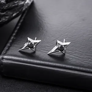 Macro view of silver four-pointed star stud earrings with black center stones
