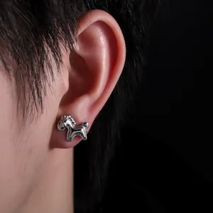 Close-up view of a minimalist silver horse-shaped stud earring worn on a model's ear