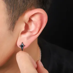 Detailed close-up of a black four-pointed star stud earring with blue accents on ear.