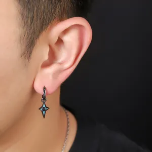 Detailed close-up showing a black four-pointed star pendant earring worn on a male ear.