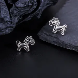 Detailed macro view of silver horse-shaped stud earrings showing high-polished finish