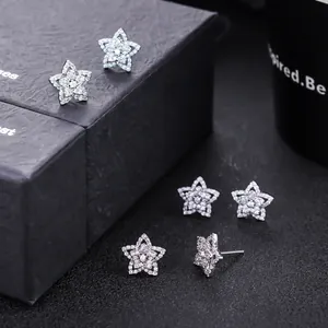 Vue rapprochée de boucles d'oreilles étoile avec zircons sur un fond noir texturé
