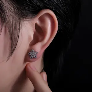 Détail macro de boucles d'oreilles étoile serties de zircon avec design minimaliste