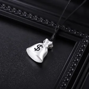 Macro view of a silver money bag pendant with a dollar sign on a black cord necklace