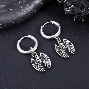 Detail view of stainless steel skull and bat wing charm hoop earrings with vintage finish.