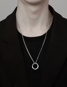 Vue rapprochée d'un collier avec pendentif anneau de Möbius minimaliste pour hommes
