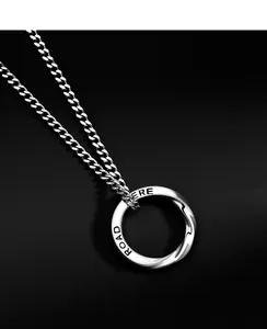 Gros plan d'un pendentif anneau Mobius en argent avec gravure sur une chaîne en métal