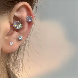 Close-up detail of sparkling zircon magnetic earrings in various sizes worn on the ear