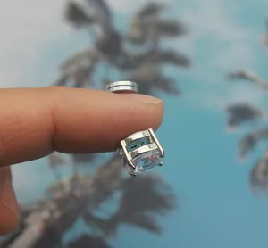 Detailed view of a silver magnetic non-pierced stud earring with a square cut crystal.