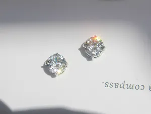 Detailed close-up of round-cut solitaire stud earrings with a four-prong silver setting
