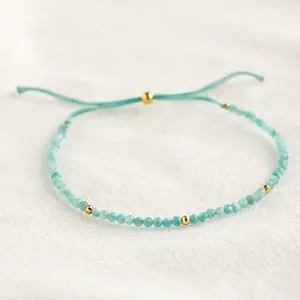 Detailopname van een Boheemse kralenarmband met blauwe halfedelstenen en gouden kralen