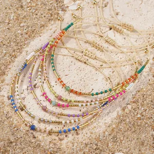 Exquisite multi-color seed bead bracelets with gold accents for women on a sandy background
