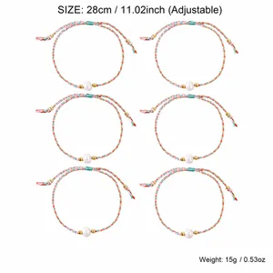 Close-up showing six colorful braided bracelets with pearl beads and weight details