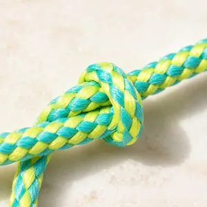 Macrodetail van een blauw en groen gevlochten 8-strengs touwknoop op stenen oppervlak