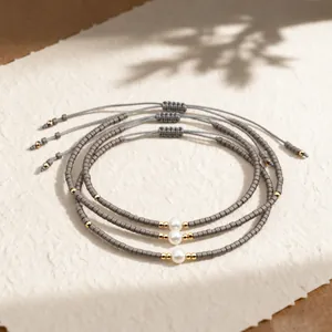 Set of three handmade grey bead bracelets with pearl accents and adjustable cord