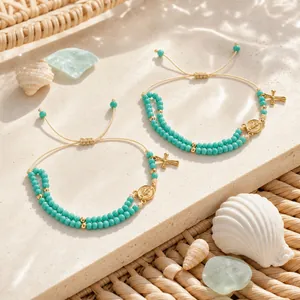 Elegant blue handmade beaded bracelet for women with gold-tone cross and coin charms