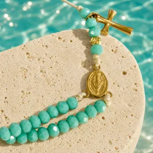 Handmade blue faceted beaded bracelet featuring gold cross and religious coin charms on stone