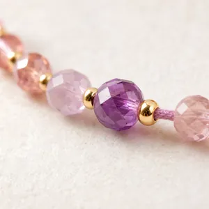 Gros plan d'un bracelet de perles tressé à la main avec cristaux facettés violets roses