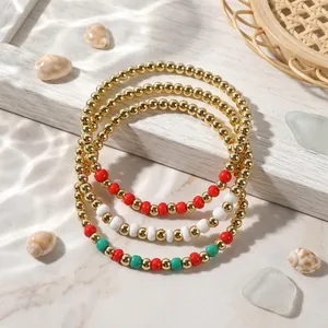 Three-piece Christmas beaded bracelet set with gold, red, and green beads for holiday parties.