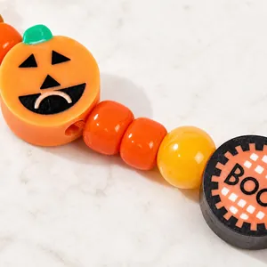 Primo piano di un festoso braccialetto di perline di Halloween con zucca e perle BOO