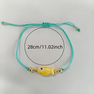 Vue d'ensemble d'un bracelet tressé vert menthe avec charm poisson jaune et perles